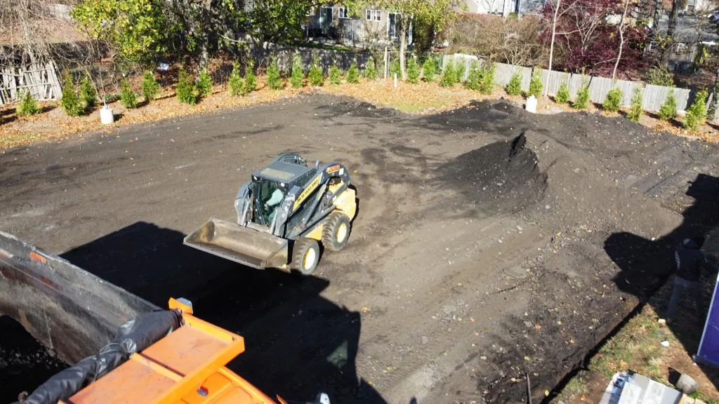 Construction vehicle leveling a worksite.