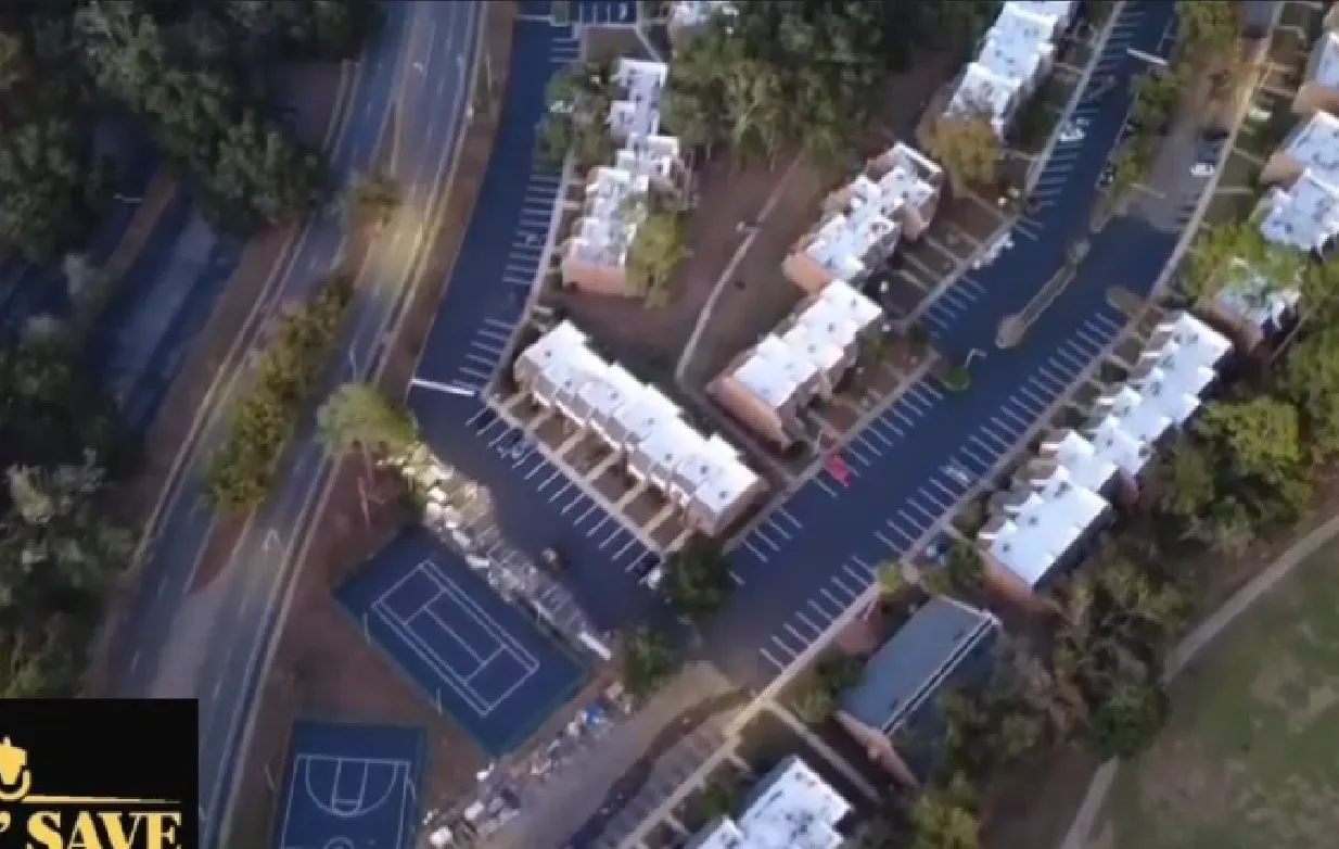 Aerial view of a freshly paved commercial area with clear parking lines and a basketball court, completed by Pave N Save.